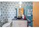 Well-lit bathroom with blue tile accents, classic wallpaper, and a vanity area at 4908 S Bedford Ln, Lakeland, FL 33813