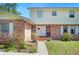 Close-up of a charming home's entryway with a white door, brick accents and colorful flowers and plants at 4908 S Bedford Ln, Lakeland, FL 33813