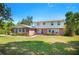 Charming two-story home with a brick facade, white shutters and a well-maintained front yard and lush landscaping at 4908 S Bedford Ln, Lakeland, FL 33813