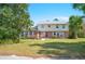 Charming two-story home with a brick facade, white shutters and a well-maintained front yard and lush landscaping at 4908 S Bedford Ln, Lakeland, FL 33813