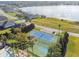 Aerial shot of community sports courts including tennis and basketball, surrounded by palm trees and lush landscaping near the lake at 4929 Tennessee Lake Dr, Auburndale, FL 33823