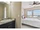 Bathroom sink and a doorway view of a cozy bedroom with a ceiling fan and lake view at 4929 Tennessee Lake Dr, Auburndale, FL 33823