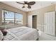 Bright bedroom featuring a ceiling fan, large window with a lake view, neutral walls and white trim at 4929 Tennessee Lake Dr, Auburndale, FL 33823