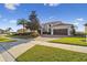 Stately home featuring a paver driveway, lush landscaping, and a three-car garage at 4929 Tennessee Lake Dr, Auburndale, FL 33823