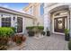 Charming front entrance featuring a decorative door, manicured landscaping, and a brick paver walkway at 4929 Tennessee Lake Dr, Auburndale, FL 33823