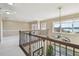 Open hallway with lake views and decorative wrought iron overlooking the downstairs living area at 4929 Tennessee Lake Dr, Auburndale, FL 33823