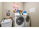 Functional laundry room with modern washer and dryer, sink, and ample storage space at 4929 Tennessee Lake Dr, Auburndale, FL 33823