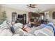 Open-plan living room featuring a dark entertainment center, ceiling fan, and an eat-in kitchen in the background at 4929 Tennessee Lake Dr, Auburndale, FL 33823