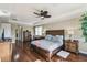 Well-lit main bedroom showcases hardwood floors, a tray ceiling, and a cozy ambiance with modern furniture at 4929 Tennessee Lake Dr, Auburndale, FL 33823