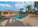 Attractive community pool with lounge chairs, umbrellas, and lush palm trees for a tropical getaway at 4929 Tennessee Lake Dr, Auburndale, FL 33823