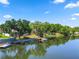 Waterfront home featuring a boat dock, mature trees, and a backyard enclosure at 502 Lake Harris Dr, Lakeland, FL 33813