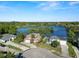 Picturesque aerial view of waterfront homes with lush landscaping, set against a backdrop of serene lake and blue skies at 502 Lake Harris Dr, Lakeland, FL 33813