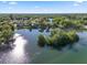 Aerial view of a waterfront home, nestled on a tranquil lake with mature trees and island in a residential neighborhood at 502 Lake Harris Dr, Lakeland, FL 33813