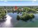 Aerial view of a waterfront home, nestled on a tranquil lake with mature trees and island in a residential neighborhood at 502 Lake Harris Dr, Lakeland, FL 33813