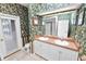 Unique bathroom featuring dual sinks with decorative wallpaper, a tile floor, and a glass door leading outside at 502 Lake Harris Dr, Lakeland, FL 33813