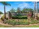 Well-maintained community entrance sign with lush landscaping and prominent branding at 502 Lake Harris Dr, Lakeland, FL 33813