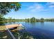 Waterfront view from the yard featuring a private dock, landscaping, and lush foliage at 502 Lake Harris Dr, Lakeland, FL 33813