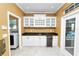 Wet bar featuring white cabinets, granite counters, tile floors, wine rack, and stainless steel appliances at 502 Lake Harris Dr, Lakeland, FL 33813