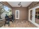 Outdoor covered patio featuring a grill, tile flooring, and views of the yard and surrounding trees at 502 Lake Harris Dr, Lakeland, FL 33813