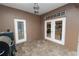 Spacious tiled patio featuring outdoor seating, a grill, and french doors leading into the main residence at 502 Lake Harris Dr, Lakeland, FL 33813