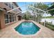 Beautiful backyard and pool area, features outdoor kitchen, seating, and tranquil lake views at 502 Lake Harris Dr, Lakeland, FL 33813