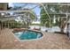 Screened in pool featuring attached hot tub, brick tiling, and tranquil lake views at 502 Lake Harris Dr, Lakeland, FL 33813