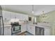 Well-lit kitchen featuring stainless steel appliances, modern white cabinets, and view to dining area at 5207 St Lucia Dr, Lakeland, FL 33812