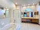 Bright bathroom with a soaking tub, walk-in shower, double vanity and decorative wallpaper at 5730 Tanasi Ct, Lakeland, FL 33812