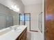 Bathroom with tiled floor, vanity, large mirror and sliding glass shower doors at 5730 Tanasi Ct, Lakeland, FL 33812