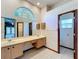 Bathroom featuring a large arched window, double vanity and neutral-toned tile floor at 5730 Tanasi Ct, Lakeland, FL 33812