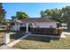 Well-maintained single-story home featuring a manicured lawn, garden beds, and a gray roof at 5730 Tanasi Ct, Lakeland, FL 33812