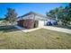 Side exterior view of a single Gathering home showcasing the yard, driveway, and garage at 5730 Tanasi Ct, Lakeland, FL 33812