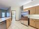 View of the kitchen featuring stainless steel refrigerator, light wood cabinets, and bright tiled floor at 5730 Tanasi Ct, Lakeland, FL 33812