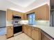 Well-lit kitchen with stainless steel appliances, light cabinetry and a window over the sink at 5730 Tanasi Ct, Lakeland, FL 33812