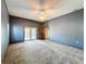 Spacious main bedroom featuring neutral carpet, ceiling fan, and French doors at 5730 Tanasi Ct, Lakeland, FL 33812