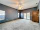 Large main bedroom featuring neutral carpet, ceiling fan, and French doors at 5730 Tanasi Ct, Lakeland, FL 33812