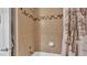 Clean and well-maintained bathroom with tiled walls, shower head, and decorative shower curtain at 5798 Dornich Dr, Auburndale, FL 33823