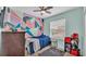 Bright bedroom with a unique painted accent wall, ceiling fan, and comfortable carpet at 5798 Dornich Dr, Auburndale, FL 33823