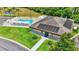 Community clubhouse with a pool, solar panels, and an American flag, surrounded by lush landscaping and trees at 6211 Crane Dr, Lakeland, FL 33809