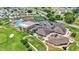 An aerial view of the community amenities, including a clubhouse, pool, tennis courts, and golf greens at 6211 Crane Dr, Lakeland, FL 33809