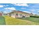 Back exterior of home with a green lawn and various windows for natural light at 6211 Crane Dr, Lakeland, FL 33809