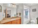 Well-lit bathroom featuring a large mirror, granite countertops, and a shower with lavender tile at 6211 Crane Dr, Lakeland, FL 33809