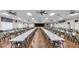 A spacious meeting hall with tables, chairs, ceiling fans, and a stage, ideal for social gatherings and events at 6211 Crane Dr, Lakeland, FL 33809