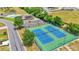 Aerial view of community tennis courts with blue playing surfaces, green fencing, and mature landscaping at 6211 Crane Dr, Lakeland, FL 33809