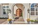 Elegant entryway with an arched doorway, wood double doors, and beautiful potted plants at 6383 Summertimes Plantation Blvd, Bartow, FL 33830