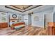 Large main bedroom featuring wood-look floors, tray ceilings, a ceiling fan and neutral tones at 6383 Summertimes Plantation Blvd, Bartow, FL 33830