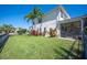 Spacious backyard with lush grass, palm trees, and view of home's screened lanai at 6515 Eagle View Loop, Lakeland, FL 33813