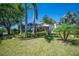 Professionally landscaped backyard with mature palms and view of the home's screened pool area at 6515 Eagle View Loop, Lakeland, FL 33813