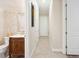 Bathroom featuring decorative mosaic tiling, a wooden vanity, and a bright, well-lit hallway at 6515 Eagle View Loop, Lakeland, FL 33813