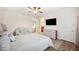 Bedroom with ceiling fan, ensuite, TV, accent wall, and light brown tile flooring throughout at 6515 Eagle View Loop, Lakeland, FL 33813